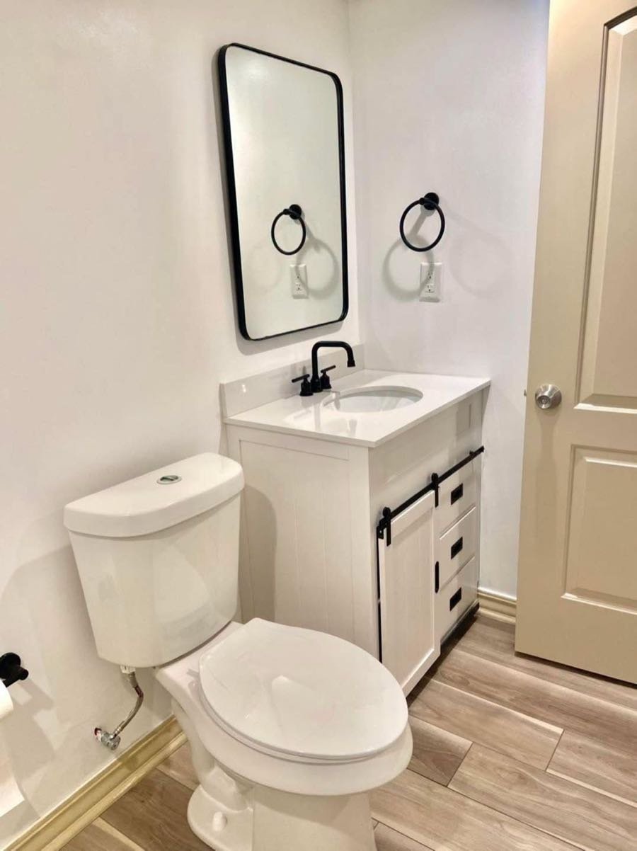 Powder room with a white vanity and black fixtures